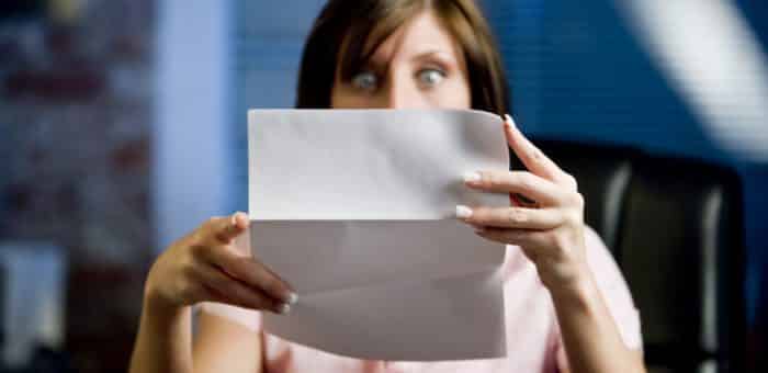 Hero image of a woman expressing shock while reading her electric bill.