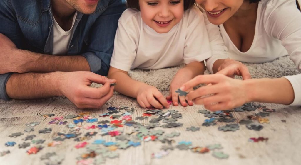 Family playing with puzzle. Power Wizard answers your All Electric Home Heating questions.