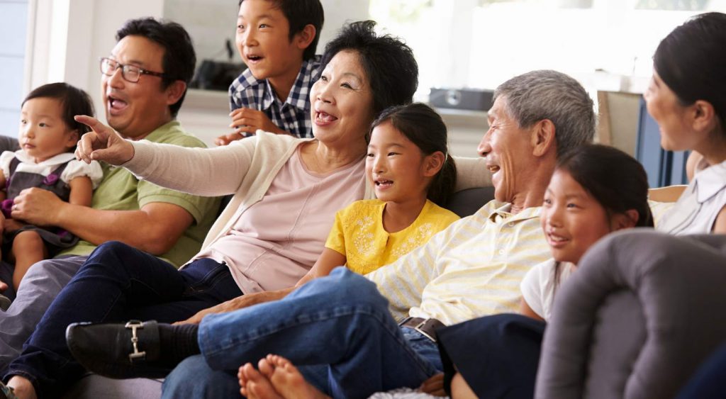 Happy family on couch watching show - Champion Energy