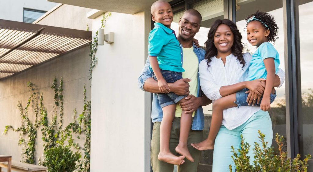 Happy family outside home. Cost Of Living In Texas
