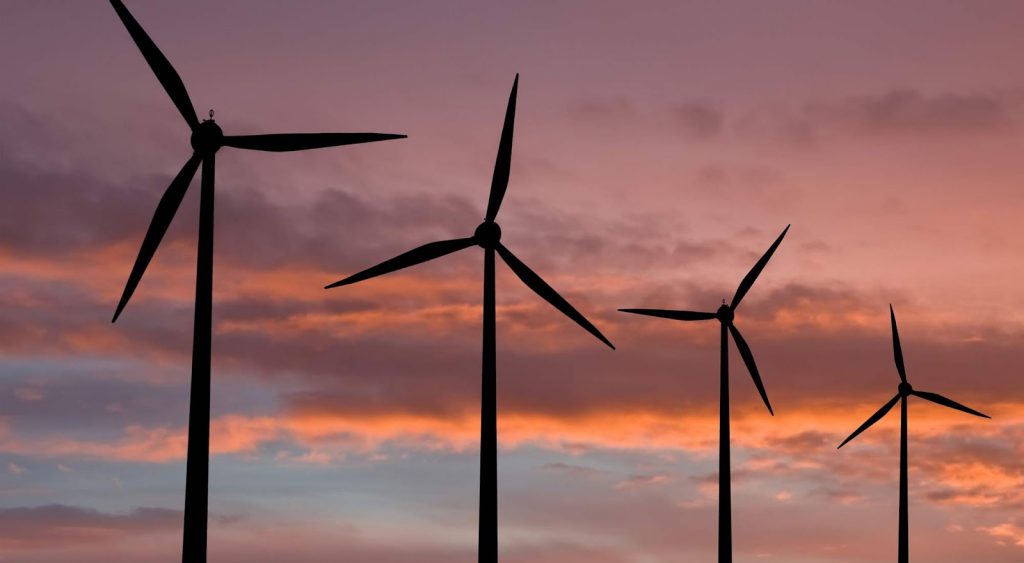 Windmills at sunset. Cost Per Kwh By Source