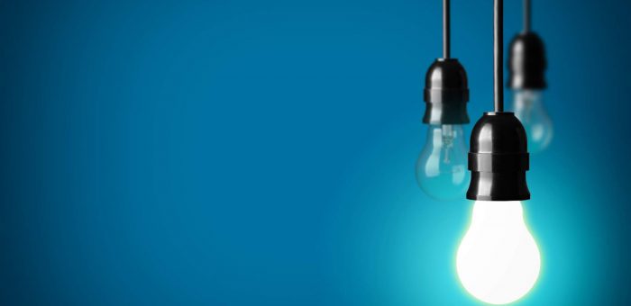 Lightbulbs hanging against blue wall. Electric Companies In Central Texas