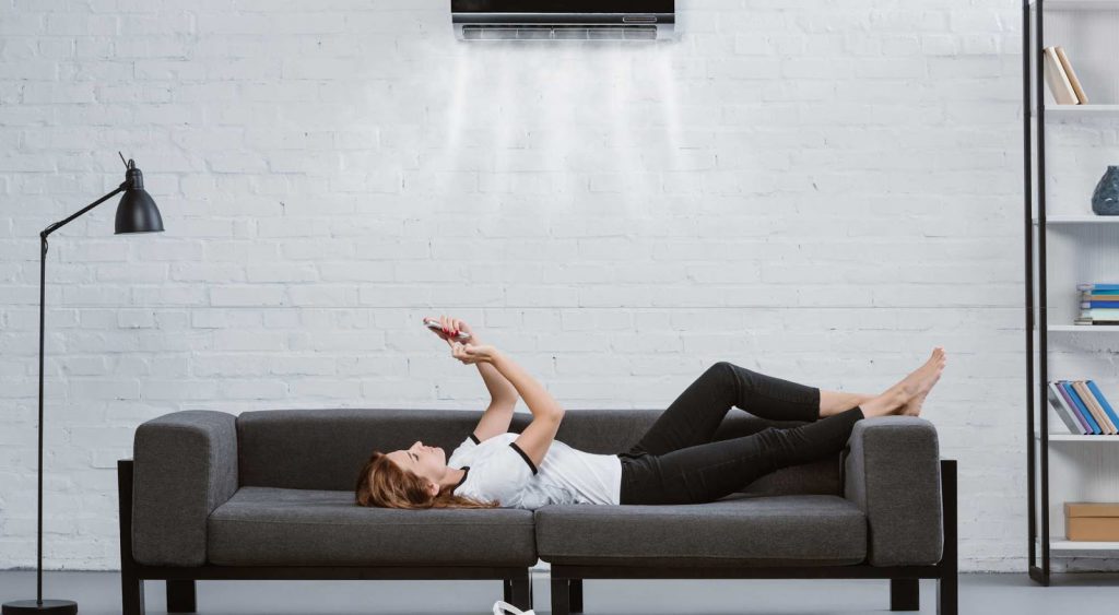 Woman on couch - Fan vs Air Conditioner Electricity