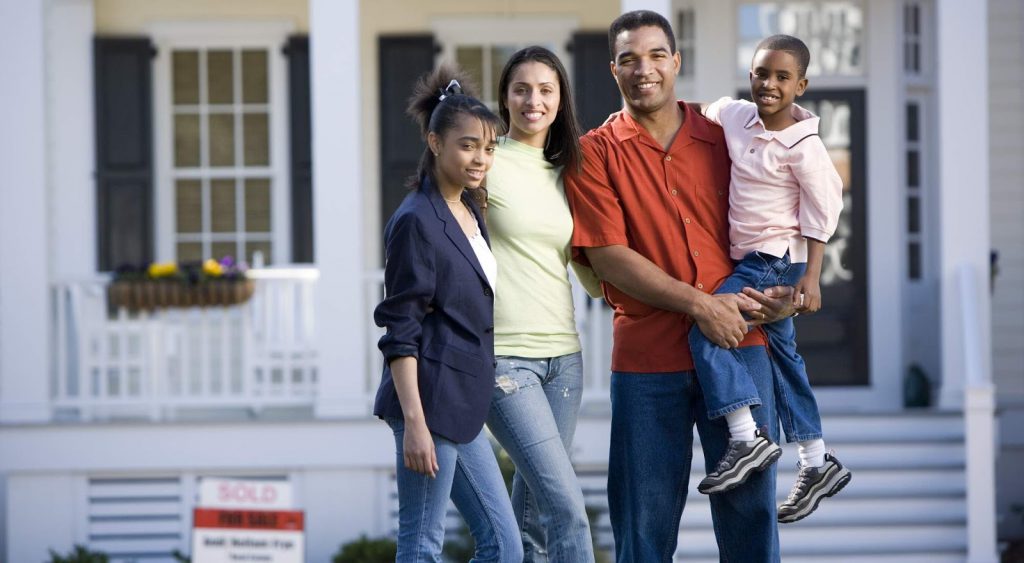 A family of first choice power customers standing outside of their house.