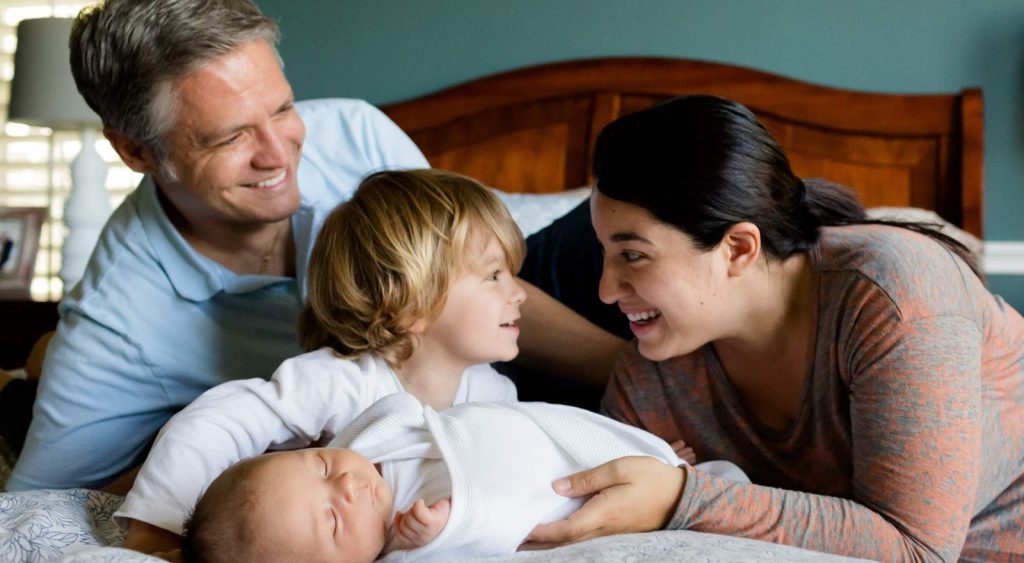 Happy family on bed. Green Energy Exchange