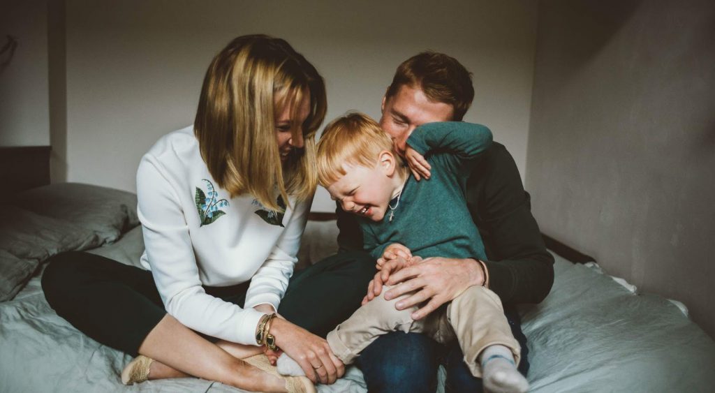 Happy family on bed. Green Mountain Energy