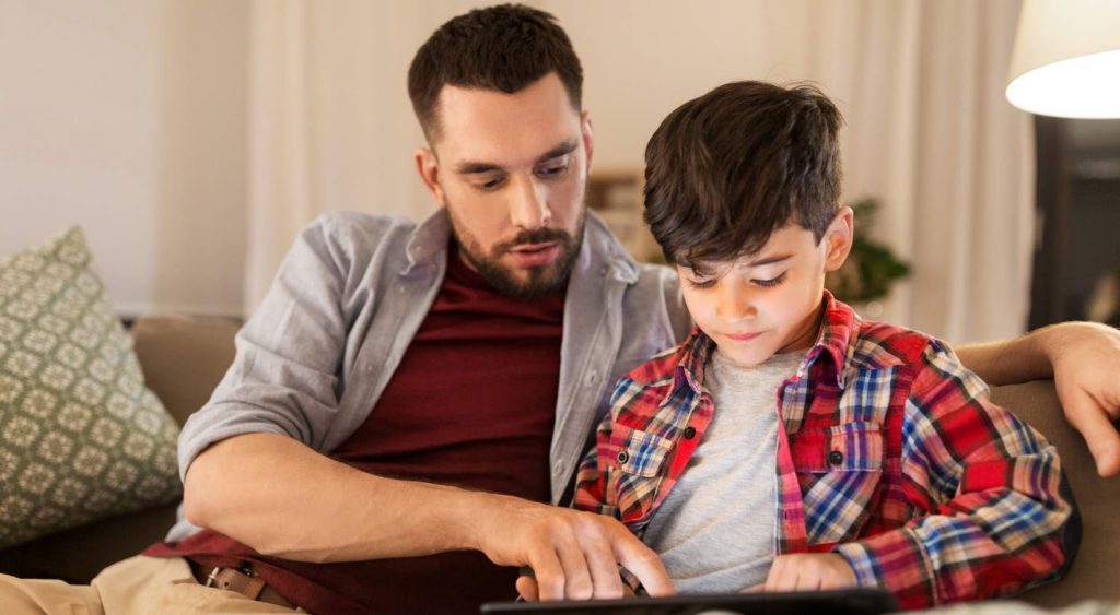 Father and son with device - Is Commercial Electricity Cheaper Than Residential