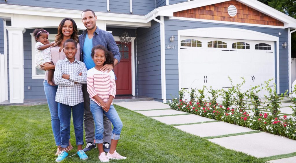 Happy family in front of blue house - Think Energy