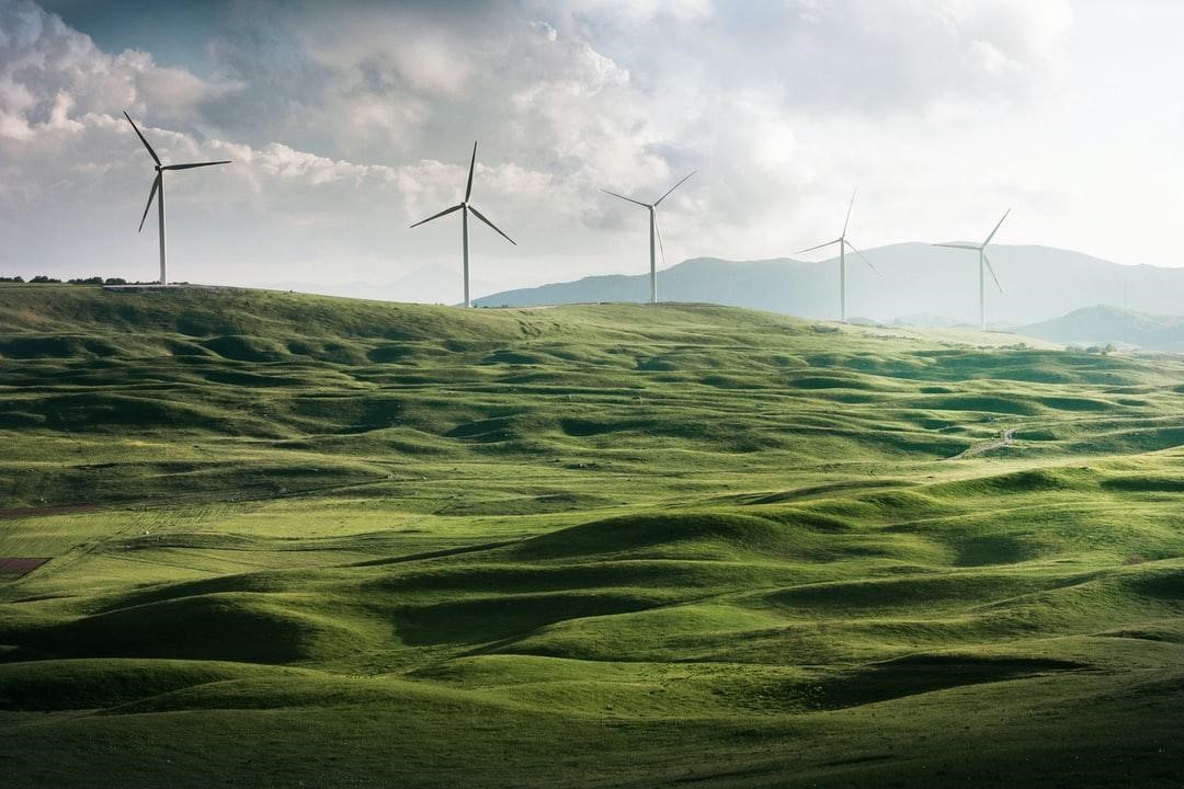 Row of WindMills on a Green Hill
