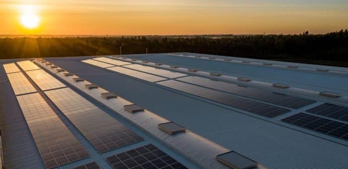 solar panels on a roof with a sunset in the background