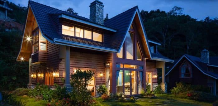 a cabin at night with the lights on in the windows
