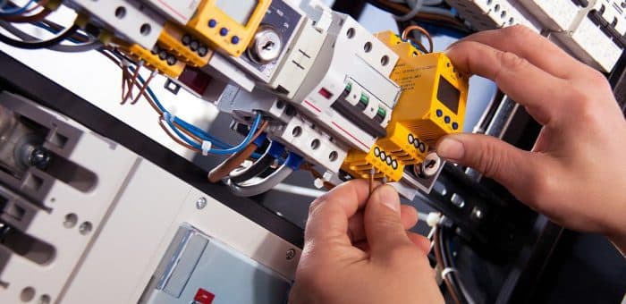 hands working on an electrical device