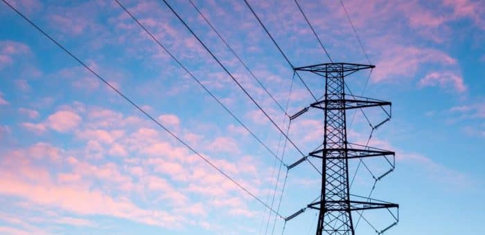 a blue sky with pink clouds and a power pole with power lines