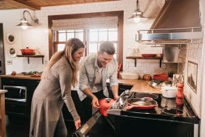 A woman and man putting a dish in the oven in a beautiful kitchen
