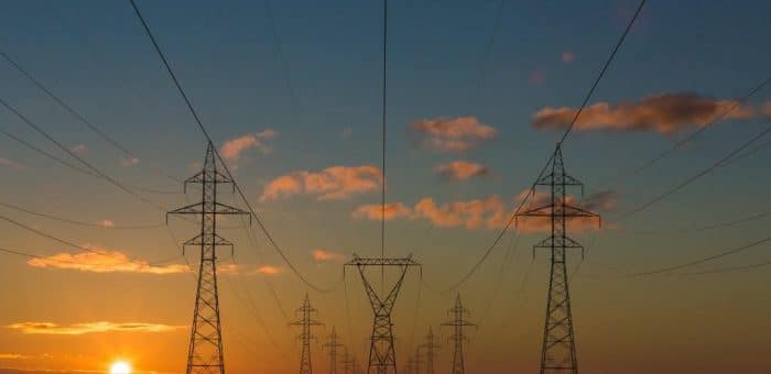 sun setting with electricity poles