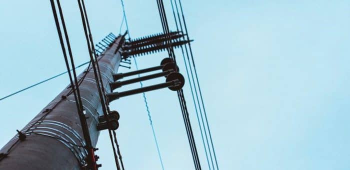 An electricity pole with a blue sky and no clouds