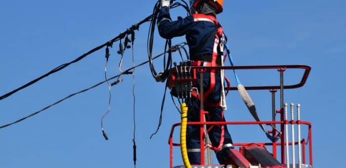 A person on a lift working on the power lines