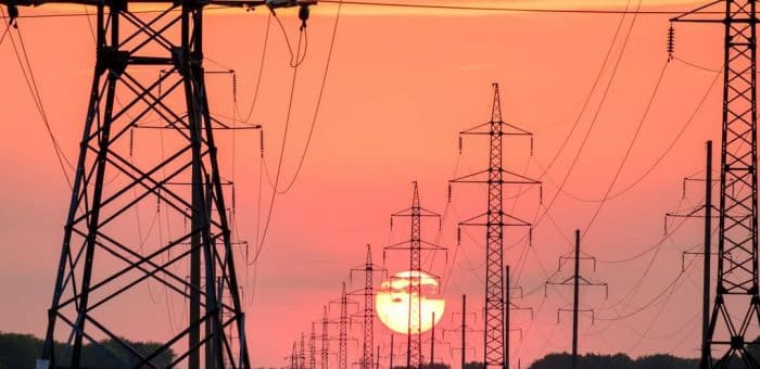 An orange and red sunset with power lines across.