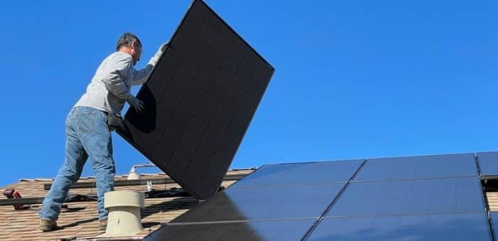 Man installing solar panel on roof