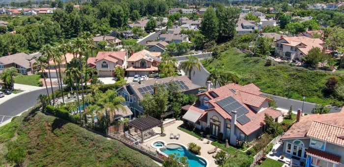an aerial photograph of solar panels on mansions in a neighborhood